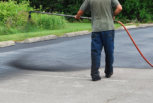 Spraying new sealer coat on an asphalt parking lot. Spraying new sealer coat on an asphalt parking lot.